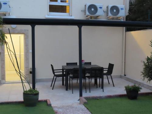 une table et des chaises noires sur une terrasse avec haut-parleurs dans l'établissement Chambre avec grand lit et salle de bain privative pour 2 personnes, à Bondy