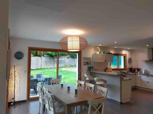 une cuisine et une salle à manger avec une table et des chaises dans l'établissement Le Paradis de Sophie, à Loctudy