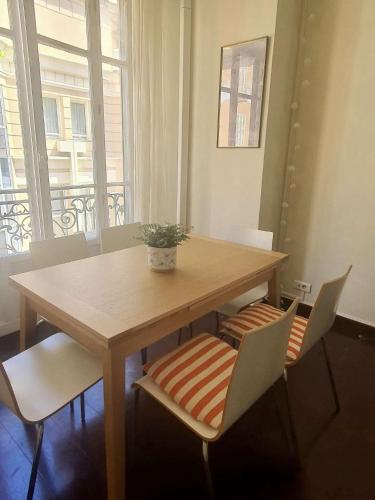 une table en bois avec des chaises et une plante au-dessus dans l'établissement Authentique et spacieux 3 pieces, à Beausoleil
