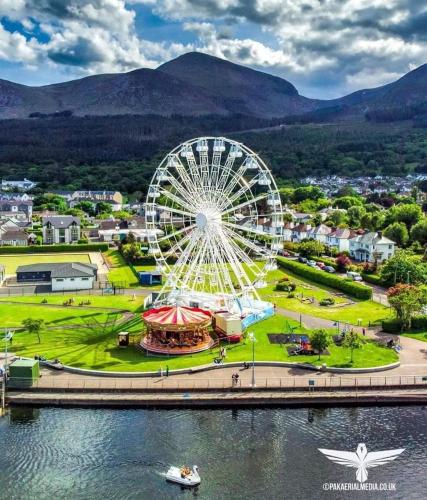 a ferris wheel in a park next to a body of water at Bryansford Cottage Stables in Bryansford