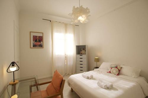 - une chambre avec deux lits, une chaise et un lustre dans l'établissement Authentique et spacieux 3 pieces, à Beausoleil