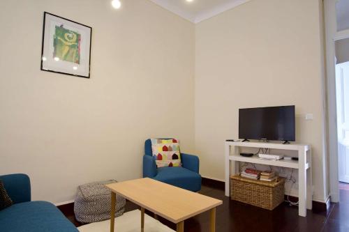 un salon avec deux chaises bleues et une télévision dans l'établissement Authentique et spacieux 3 pieces, à Beausoleil