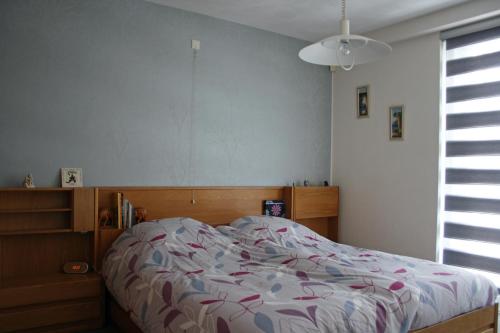 a bedroom with a bed with a floral comforter at Bed & Breakfast VanAgt in Vlijmen