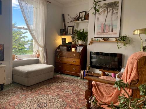 a living room with a fireplace and a chair at One-bedroom Apartment Sea Views in Rustington