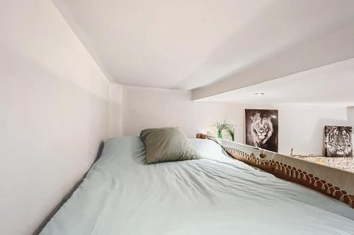 une chambre avec un grand lit dans une pièce blanche dans l'établissement Charming Studio Near Le Louvre Rivoli, à Paris