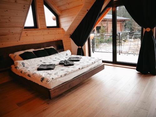 a bedroom with a bed in a room with windows at Grand Chalet Donovaly in Donovaly