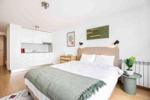 a white bedroom with a bed and a table at Saint Laurent 33-35 by Homenhancement in Lausanne