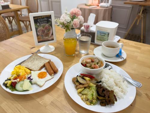a table with two plates of breakfast food and coffee at Regent Ramkhamhaeng 22 in Bangkok