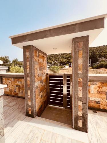 an outdoor patio with a brick wall and a door at ALTAVILLAS maisonettes in Kakí Vígla
