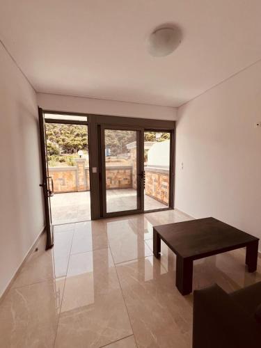 a living room with a table and sliding glass doors at ALTAVILLAS maisonettes in Kakí Vígla