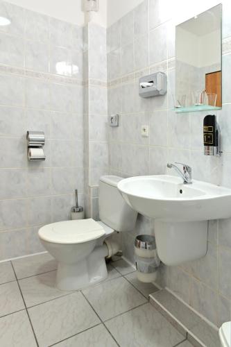 a bathroom with a white toilet and a sink at Hotel Classic in Nový Bydžov
