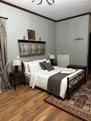 a bedroom with a large bed with white sheets at George Room 2 in Arachova