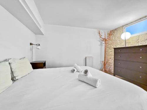 une chambre avec un grand lit blanc avec des serviettes dessus dans l'établissement Tres bel Appartement 5P Montmartre, à Paris