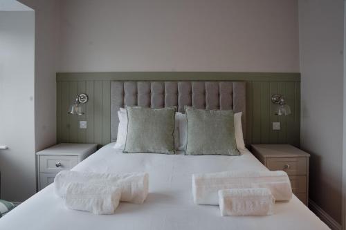 ein Schlafzimmer mit einem weißen Bett mit zwei Handtüchern darauf in der Unterkunft Lime Kiln Cottage in Bridlington