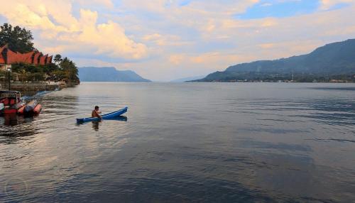 a person in a kayak on a large body of water at Zoé’s Paradise Waterfront Hotel in Tuk Tuk