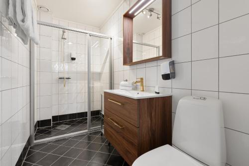 a bathroom with a toilet and a sink and a shower at Enter Tromsø - Exclusive Apartments in Tromsø