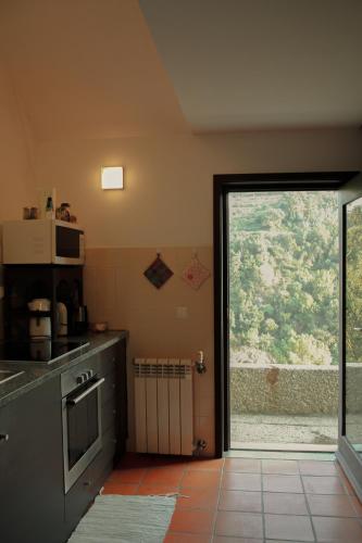 a kitchen with a large sliding glass door with a window at Casa de Gondomil in Alpendurada