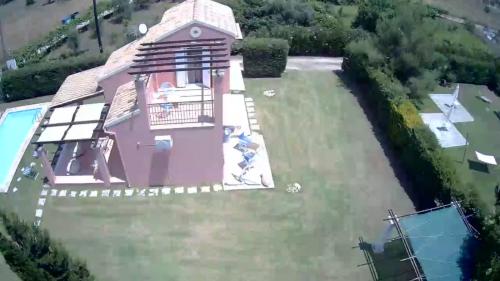 an aerial view of a pink house in the water at Villa Filia in Almiros Beach