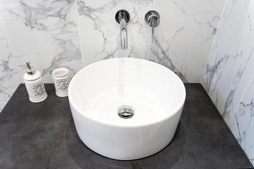 a white sink in a bathroom with marble walls at Alexia Studios in Kolios