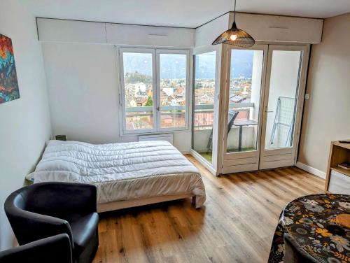 une chambre avec un lit et une grande fenêtre dans l'établissement Studio avec vue lac au centre ville proche des Thermes, à Aix-les-Bains