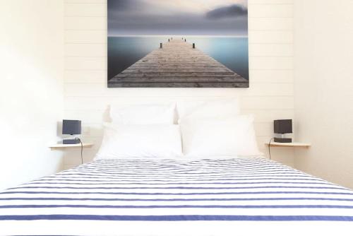 a bedroom with a bed with a picture of a pier at Chalet Alaric & Jacuzzi Ilot 1 rang1! VUE MER! 4rooms! CLIM 10p 24H24 in Gruissan