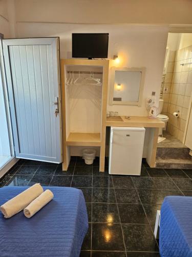 a bathroom with two beds and a desk and a sink at Skala Sunset Hotel and spa in Ios Chora