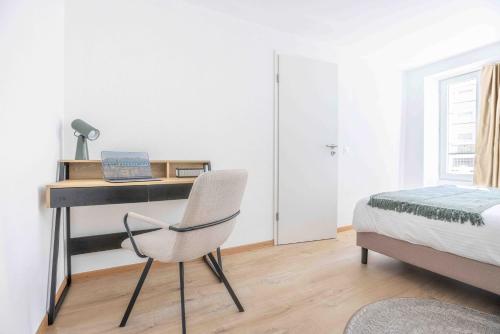 a bedroom with a desk and a bed and a chair at Saint Laurent 33-35 by Homenhancement in Lausanne