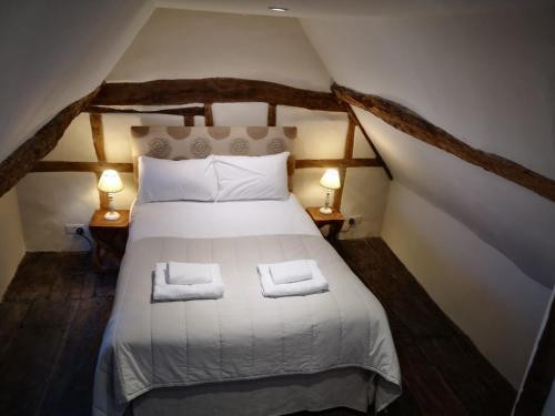 una camera da letto con un letto con due asciugamani sopra di West Pallant Georgian Townhouse in City Centre with Courtyards, BBQ & Log Burners - Dogs Welcome! Chichester Holiday Properties a Chichester