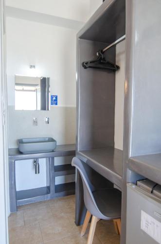 a bathroom with a sink and a vanity with a mirror at Skala Sunset Hotel and spa in Ios Chora