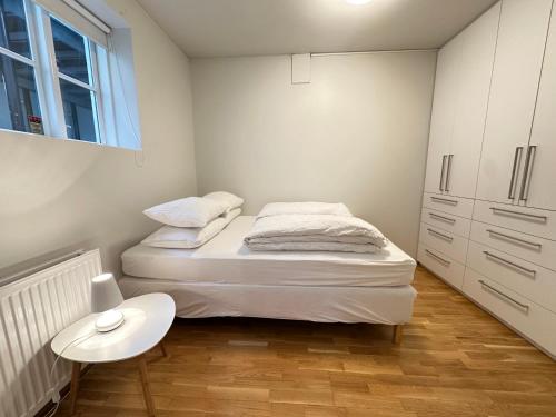 雷克雅未克Apartment in downtown Reykjavik - Birta Rentals的一间白色的小卧室,配有一张床和一张桌子