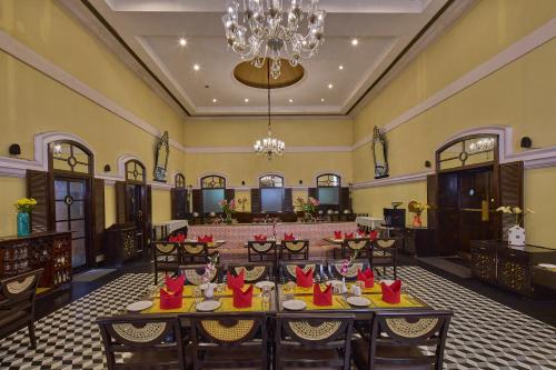 a dining room with tables and a chandelier at Royal Orchid Metropole Mysore in Mysore