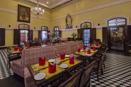 a restaurant with tables with red napkins on them at Royal Orchid Metropole Mysore in Mysore