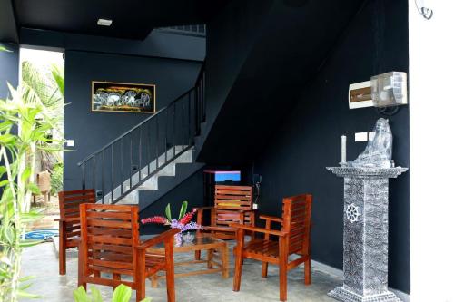 a dining room with chairs and a table and a staircase at Surf Heavens in Dickwella