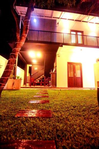 a night view of a house with a tree in the yard at Surf Heavens in Dickwella