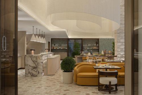 a restaurant with a yellow couch and a bar at Delano Dubai at Bluewaters in Dubai