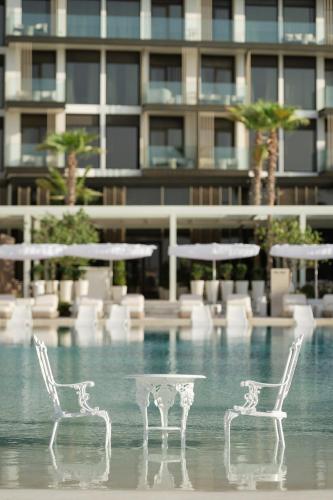 two chairs and a table in front of a building at Delano Dubai at Bluewaters in Dubai