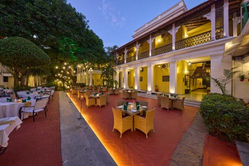 an outdoor restaurant with tables and chairs in front of a building at Royal Orchid Metropole Mysore in Mysore