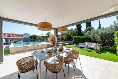 a patio with a table and chairs and a pool at Villa Jelena in Mlini