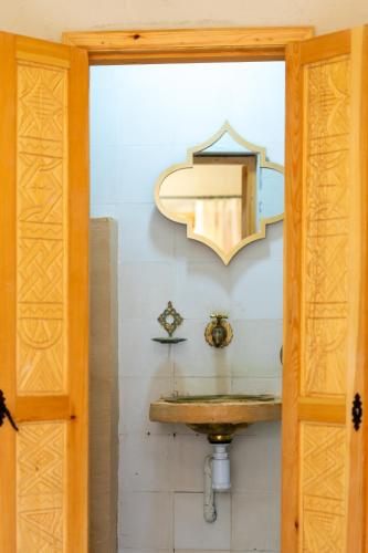 a bathroom with a sink and a mirror on the wall at Anza surfhouse in Agadir