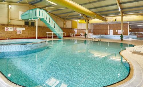 a large swimming pool with a slide in it at Privately Owned 2-bedroom Caravan at Camber Sands, 1 sofa bed, Private Parking, NO SMOKING NO PETS in Camber