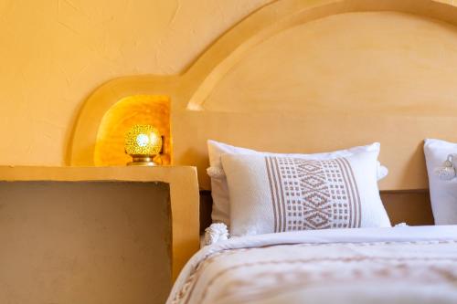 a bedroom with a bed with a wooden headboard and a lamp at Anza surfhouse in Agadir