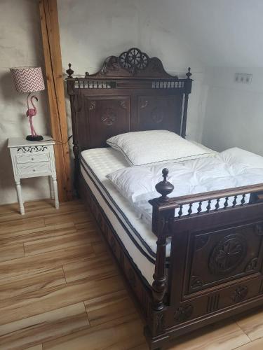 a bedroom with a large wooden bed with white sheets at Ferienhaus Siegstrand in Mittelhof