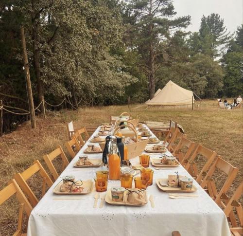 a long table with plates of food and a tent at A Leira 116 Cabañas de diseño in Sarria