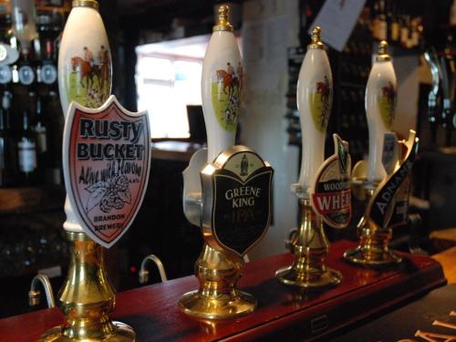 a group of vases sitting on a shelf in a bar at The Black Bull Inn in Balsham