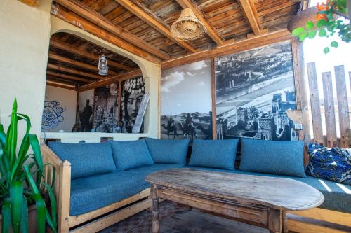 a living room with a blue couch and a table at Anza surfhouse in Agadir