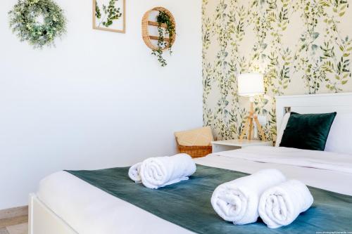 een slaapkamer met twee witte handdoeken op een bed bij Eden Luxury Home in Puerto de Santiago