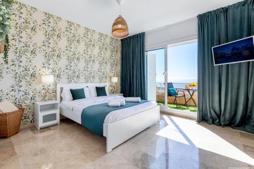 een slaapkamer met een bed en een groot raam bij Eden Luxury Home in Puerto de Santiago
