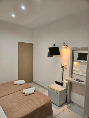 a bedroom with two beds and a phone on the wall at Skala Sunset Hotel and spa in Ios Chora