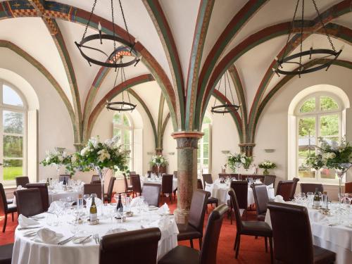 a dining room with tables and chairs with white tablecloths at Abbaye de la Bussière in La Bussière-sur-Ouche