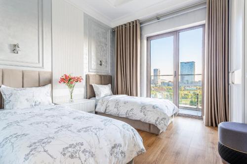 a hotel room with two beds and a window at Dreamy Luxury Apartment in Tashkent